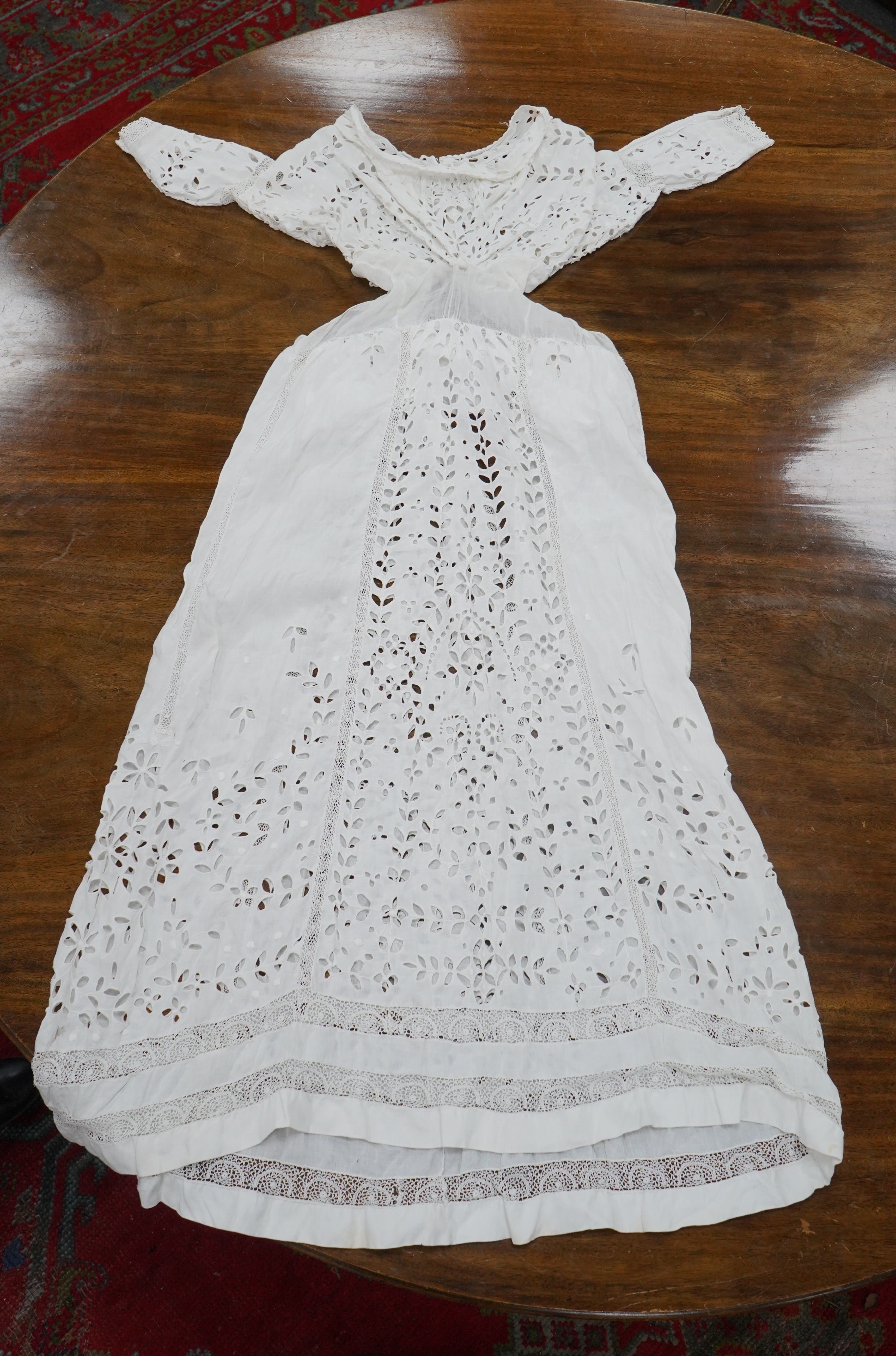 An Edwardian fine white embroidery anglaise and Irish crochet trimmed ladies summer dress, designed with large panels of anglaise cut work, the dress has been altered and restyled, which could be altered back, 134cm long